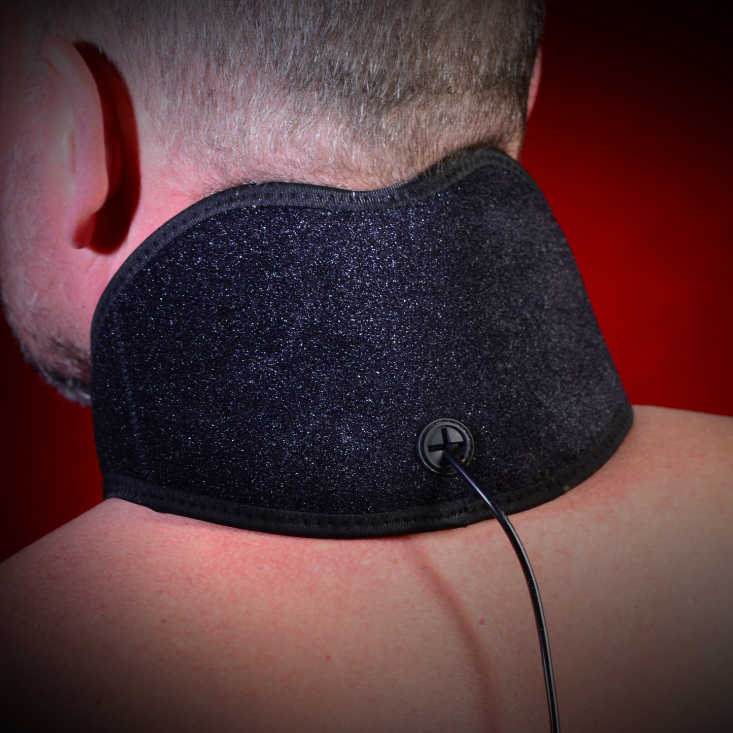 EdenPURE TotalRELIEF specialty heating pad worn on back of neck with black fabric and attached power cord