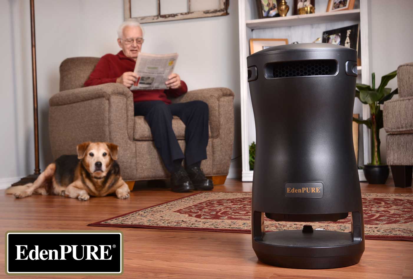 EdenPURE 360 Super Climater heater in black standing on wood floor with elderly man and dog relaxing in background